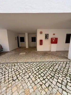 a sidewalk with a sign next to a palm tree at MyInzu - Club Albufeira Village Garden in Albufeira