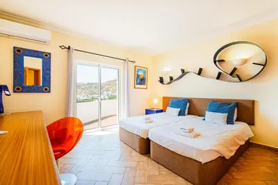a bedroom with a large bed and a table at Villa Okapi by Atlantic Places in Albufeira
