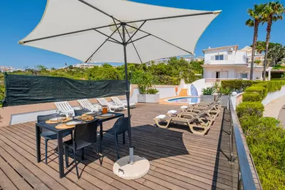 a table and chairs under an umbrella on a patio at Villa Okapi by Atlantic Places in Albufeira