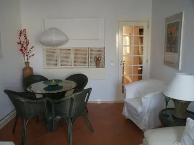 a living room with a table and chairs and a couch at Akisol Vilamoura Rise in Quarteira