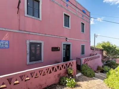 a pink building with a fence in front of it at Akivillas Loulé Holiday in Espargal
