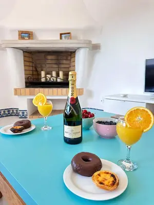 a bottle of wine and a plate with a doughnut and glasses at Villa Brasil by BeCherish in Quarteira