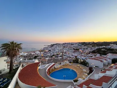 a city with a palm tree and the ocean at Breathtaking Ocean & City Views by BeCherish in Albufeira