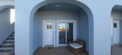 a building with two arches and a white bench at Almancil Residence in Almancil