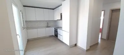 a large kitchen with white cabinets and a wooden floor at Almancil Residence in Almancil