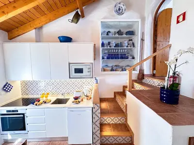a small kitchen with white cabinets and a staircase at Charming AlgarvianOceanfront Townhouse by BeCherish in Albufeira