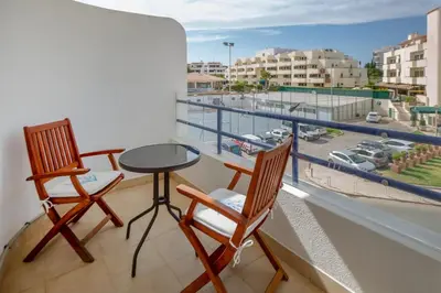 two chairs and a table on a balcony with a view of a city at Angela's in Albufeira