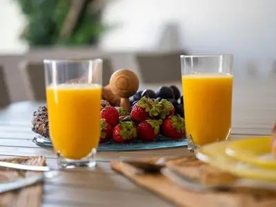 two glasses of orange juice next to a plate of fruit at Balaia Praia Apartment by Stay ici Algarve Holiday Rental in Albufeira