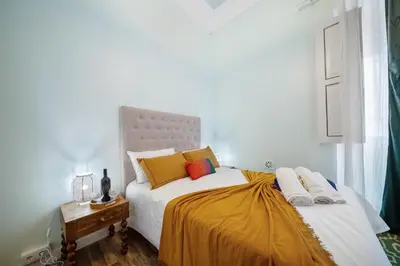 a kitchen with blue cabinets and a table and a refrigerator at Vintage Senses Residences in Faro