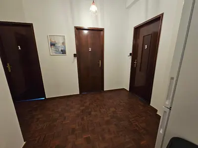 an empty hallway with two doors and wooden floors at Blife Tonya - private rooms at Santantonya 1st floor in Faro