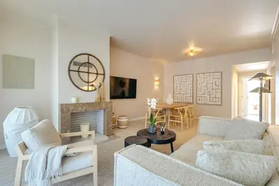 a living room with a couch and a fireplace at Apartamento T2 renovado no Vila Sol com piscina in Vilamoura
