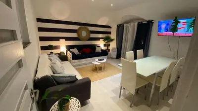 a dining room with a table and chairs and a tv at Blue Beach Home with Terrace in Albufeira