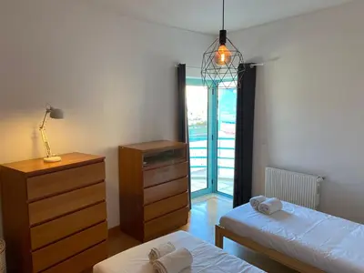 a bedroom with two beds and a dresser and a window at Marina Pool & Sea in Albufeira