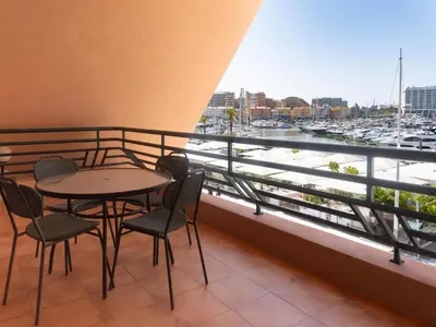 a table and chairs on a balcony with a view of a harbor at Premium Apartment with Vilamoura Marina View in Vilamoura