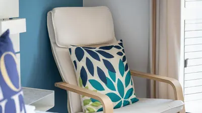 a white chair with a pillow on it in a room at Cozy 1Bdr Flat w Pool in Vilamoura by Lovelystay in Quarteira