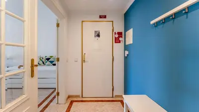 a hallway with a white door and a blue wall at Cozy 1Bdr Flat w Pool in Vilamoura by Lovelystay in Quarteira