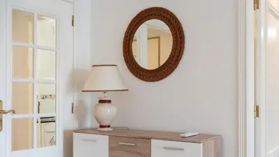 a table with a lamp and a mirror on a wall at Cozy 1Bdr Flat w Pool in Vilamoura by Lovelystay in Quarteira