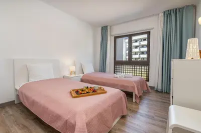 a hotel room with two beds and a tray of flowers on the bed at Vilamoura Retreat with Pool & Balcony by HostWise in Quarteira