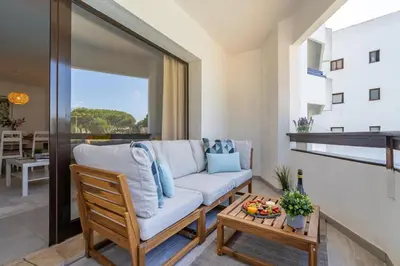 a living room with a couch and a table at Vilamoura Retreat with Pool & Balcony by HostWise in Quarteira