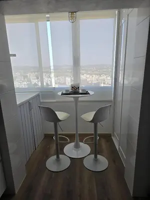 a room with a table and two stools in front of a window at CityComfort in Faro