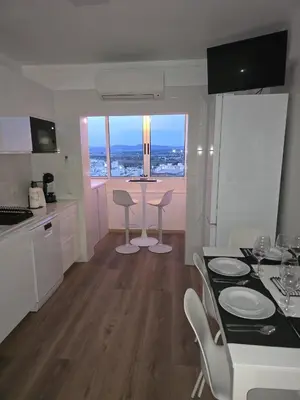 a kitchen and dining room with a table and chairs at CityComfort in Faro