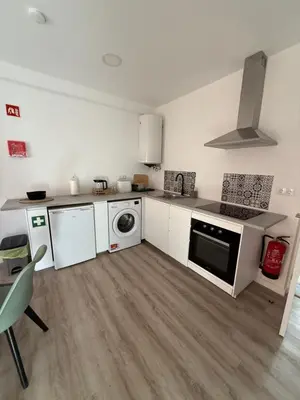 a kitchen with a stove and a washer and dryer at Camilas Place 2 in Bicas