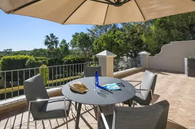 a patio with a table and chairs and an umbrella at Belinha - PINHEIROS ALTOS in Ludo