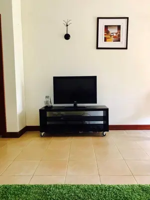 a flat screen tv sitting on top of a black entertainment center at Salgados Village, Santos Apartment in Guia