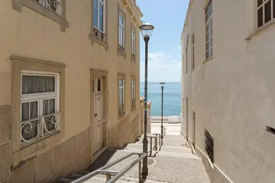 a street with buildings and the ocean in the background at Budget Beach Center B5 in Albufeira