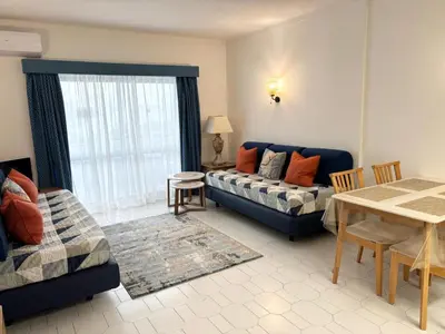 a kitchen with white cabinets and a sink and a microwave at Aqualux Golden Sun Amazing Holiday in Albufeira