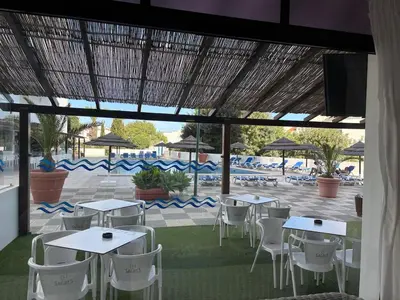 a group of tables and chairs in a patio at Aqualux Golden Sun Amazing Holiday in Albufeira