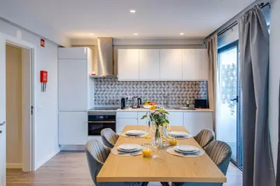 a kitchen with a wooden table and chairs in a kitchen at Stunning Ocean View Apt Beach 200mt AC Pool in Albufeira