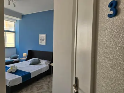 a bedroom with a bed with a blue wall at Blife Brasilya - private rooms at Santantonya 2nd floor in Faro