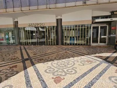 a building with a mosaic floor in front of a store at Blife Brasilya - private rooms at Santantonya 2nd floor in Faro