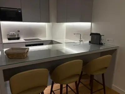 a kitchen with a counter with two chairs and a sink at Quarteira Horizon Sea in Quarteira