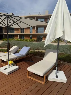 three lounge chairs and an umbrella on a deck at Quarteira Horizon Sea in Quarteira