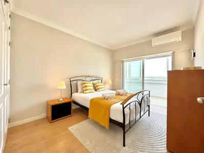 a bedroom with a bed and a window at Quarteira Central Beach 5 by Homing in Quarteira