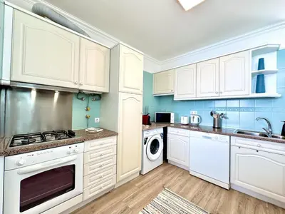 a kitchen with white cabinets and a washer and dryer at Quarteira Central Beach 5 by Homing in Quarteira