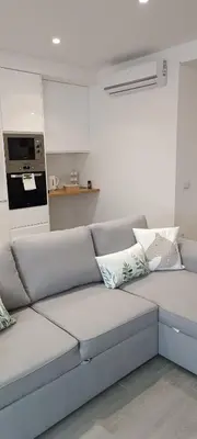a white couch with pillows in a living room at Skynest 59 Faro Airport Guest House in Faro