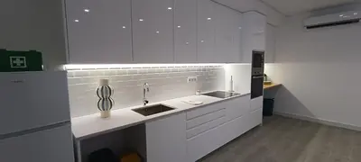 a kitchen with white cabinets and a sink at Skynest 59 Faro Airport Guest House in Faro