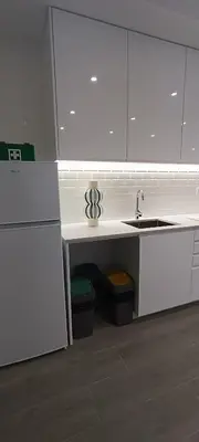 a kitchen with a sink and a counter with two trash cans at Skynest 59 Faro Airport Guest House in Faro