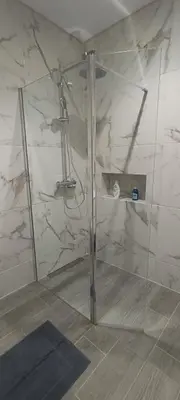 a shower with a glass door in a bathroom at Skynest 61 Faro Airport Guest House in Faro