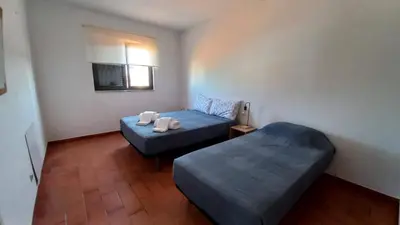a small room with two beds and a window at Villa UM in Albufeira