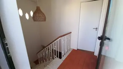 a hallway with a staircase with a door and a light at Villa UM in Albufeira