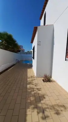 a patio outside of a white building with a wall at Villa UM in Albufeira