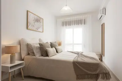 a white bedroom with a bed and a window at Mare Viva - Seafront with pool by HD in Quarteira