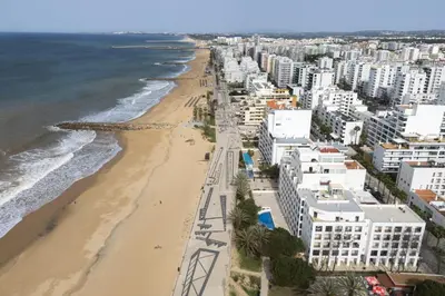 an aerial view of a beach and buildings at Mare Viva - Seafront with pool by HD in Quarteira