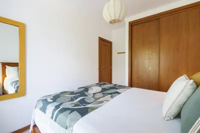 a bedroom with a bed and a mirror at 1 Bedroom apt with pool access in Albufeira