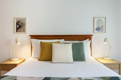 a bedroom with a white bed with two lamps at 1 Bedroom apt with pool access in Albufeira