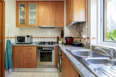 a small kitchen with a sink and a microwave at 1 Bedroom apt with pool access in Albufeira